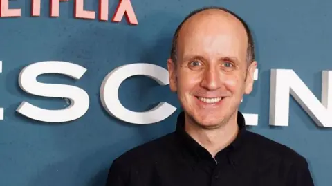 PA Media Jack Thorne wearing a black top and looking at the camera, smiling