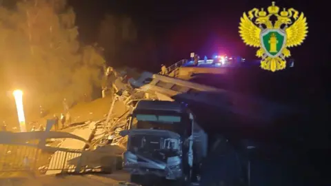 Moscow Interregional Transport Prosecutor's Office A vehicle surrounded by debris at night. People are standing a short way away watching.