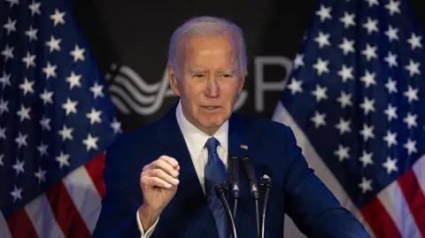 Getty Images Biden stands before the podium giving a speech at a forum in Chicago, Illinois in April