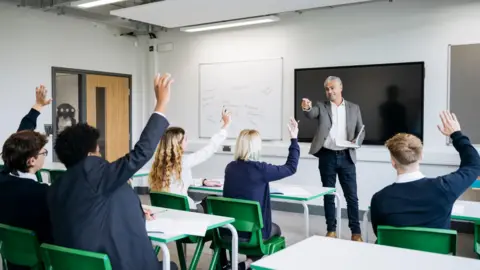 Getty Images A classroom full of school children in a lesson with a teacher at the front of the class