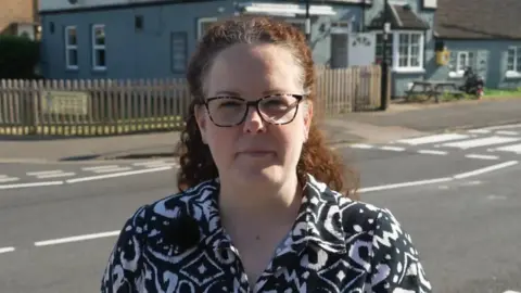 DJ McLaren/BBC Werrington Primary School mother Kerri Deboo standing near the road outside the school which used to have a school crossing patrol person working