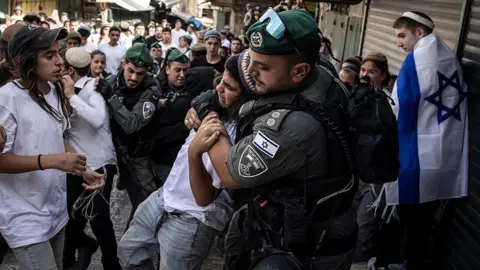 Getty Images Israeli police remove a right-wing activist in Jerusalem's Old City from a crowd during the Jerusalem Day march, 