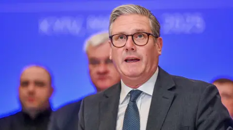 EPA Sir Keir Starmer speaking at a press conference with UK and international delegates in the background.