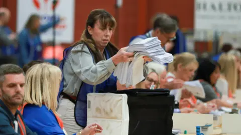Reuters Votes are taken out of a ballot box for counting on the day of the Runcorn and Helsby by-election