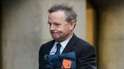 Getty Close up image of Andy Hill in suit going in to High Court in London