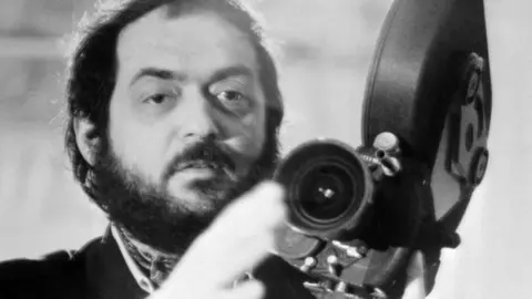 AFP/Getty Images a black and white image of Stanley Kubrick holding a film camera,