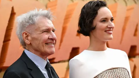 Getty Images Phoebe Waller-Bridge and Harrison Ford attend the UK premiere of Indiana Jones and the Dial of Destiny at Cineworld Leicester Square on June 26, 2023 in London, England
