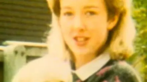 Handout Diane Sindall, who has blonde hair, smiles at the camera while holding a light coloured puppy which appears to be a labrador