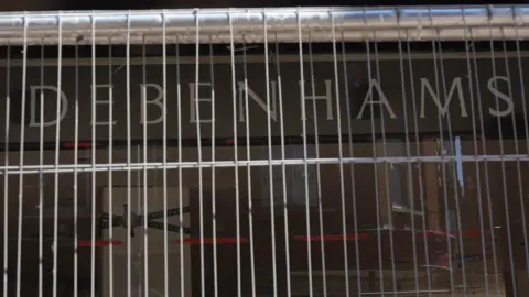 John Fairhall/BBC The front of a Debenhams store behind Heras fencing.