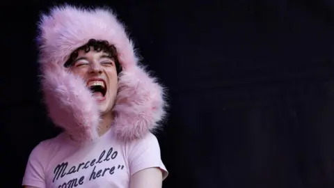 Getty Images Nemo, wearing a piunk fluffy hat and a t-shirt with the legend 'Marcello come here'