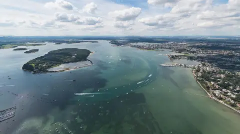 Getty Images/Thomas Faull An aerial view of Brownsea Island (to the left) and Poole Harbour (to the right). 