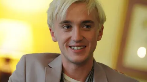 Getty Images A much younger Tom Felton being interviewed in 2009