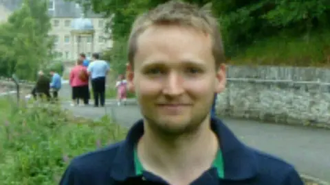 Bastian Durward Man wearing blue top with collar smiling at the camera
