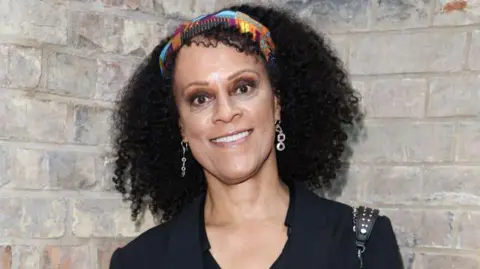 Getty Images Bernardine Evaristo, wearing a black top, a headband and dangly earrings.