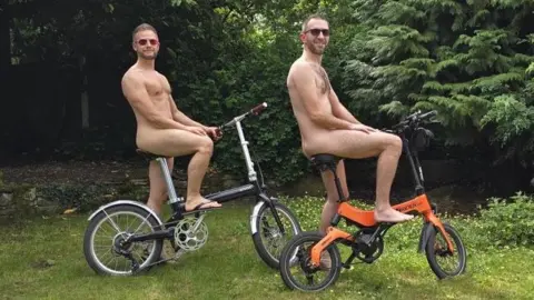 Supplied Shayne and Stephen post on their bikes naked.