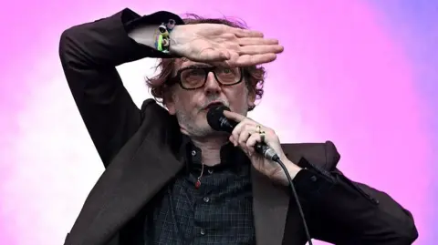 Getty Images Jarvis Cocker poses on stage at Glastonbury