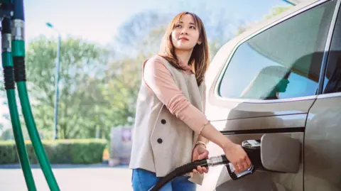 Getty Images Woman filling car