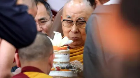 EPA/Shutterstock Tibetan Buddhism spiritual leader the Dalai Lama (C) cuts the cake during his 90th birthday celebrations