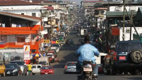 Reuters A view of a busy street in Monrovia - with many cars and shops