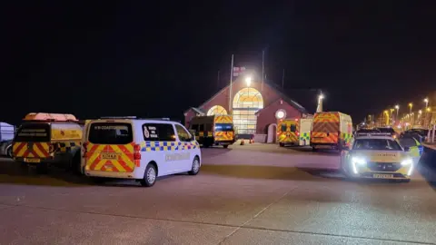 HM Coastguard Fleetwood Ambulances and police outside the boathouse - in dark night