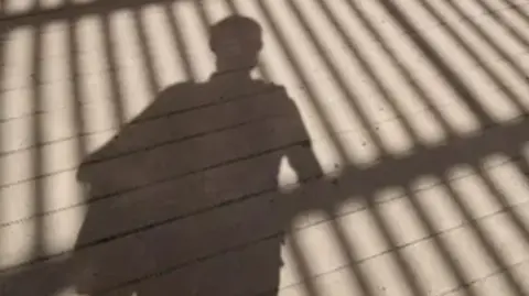Getty Images A stock image of a child's shadow in front of gates. 