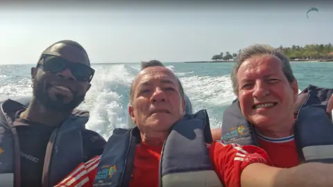 Albert Alfonso/Flickr L-R Yostin Mosquera, Albert Alfonso and Paul Longworth. They are shown smiling in a selfie, all wearing life jackets as they sit at the back of a speedboat.