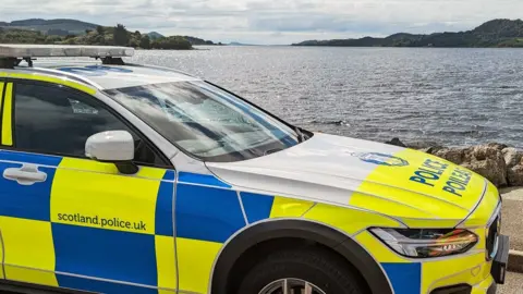 Police Scotland A police car parked at the edge of Loch Lomond