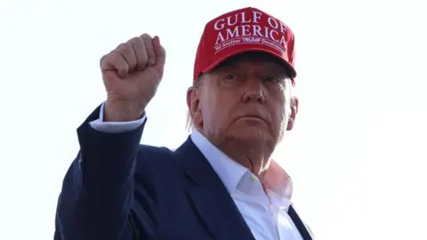 Reuters US President Donald Trump holds a fist in the air