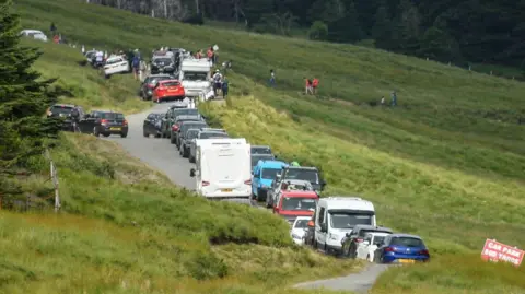 Getty Images Cars are seen lining the road as tourists visit the Fairy Pools in July 2021 in Glenbrittle.