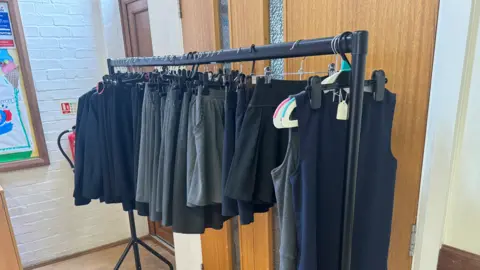 George King/BBC A rail filled with school uniform items.