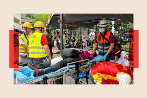 Tessa Wong/ BBC A person laying on a stretcher as part of the drills 