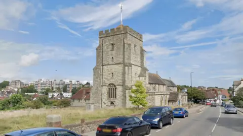 Google A grey church on a sunny day.
