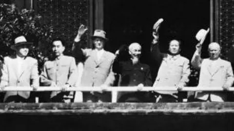 Getty Images A black-and-white photo showing a line-up of, from left to right, Chairman of the Workers' Party of Korea Kim Il-sung, first Premier of the People's Republic of China Zhou Enlai, Second Secretary of the Communist Party of the Soviet Union Mikhail Suslov, Chairman of the Workers' Party of Vietnam Ho Chi Minh, Chairman of the Communist Party of China Mao Zedong, First Secretary of the Communist Party of the Soviet Union Nikita Khrushchev
