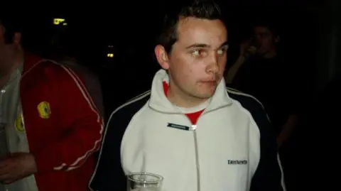 Handout Steven Cook, 20, who has brown hair syled into a peak, wearing a white zip-up hoodie holding a drink