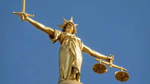 Getty Images A close-up image of the golden statue of Lady Justice.