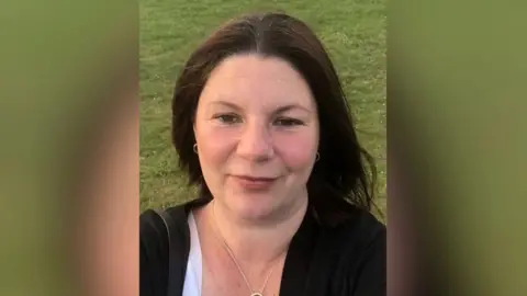 Kirsty Knight Kirsty Knight smiling for the camera in a selfie, wearing a black cardigan.