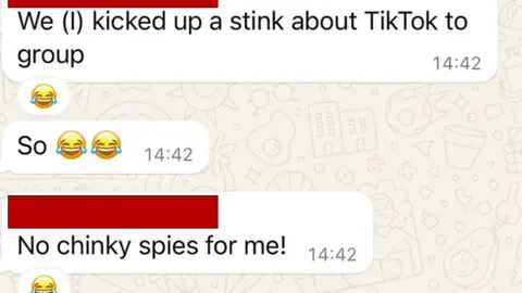 A Whatsapp screengrab which has three messages. The first says: "We (I) kicked up a stink about TikTok to group" with a laughing with tears emoji attached by someone else. The second has two laughing with tears emojis. The final one has something redacted, followed by "No chinky spies for me!". It has a laughing emoji attacked by another recipent.