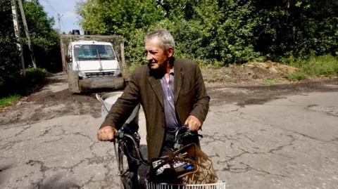Darren Conway/BBC An old man on his bicycle in Bilozerke