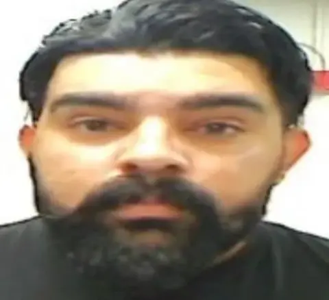 Department of Homeland Security A blurry mugshot of Harjinder Singh, who has black hair and a black beard and mustache