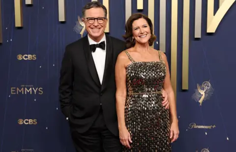 Getty Images Stephen Colbert (L) and wife Evelyn McGee-Colbert arrive for the 77th Primetime Emmy Awards at the Peacock Theatre at LA Live in Los Angeles on September 14, 2025 