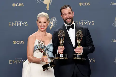 Getty Images Katherine LaNasa and Noah Wyle pose with their golden trophies at the 77th Primetime Emmy Awards