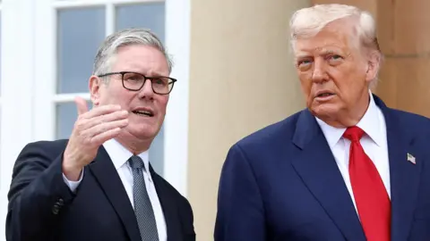 Reuters Sir Keir Starmer and Donald Trump outside a sandstone building. Starmer has raised his right hand and Trump is listening to what he is saying. Both men are wearing suits, ties and white shirts.