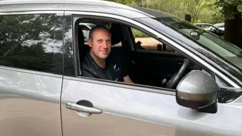 Steve Swyer Man sitting in the driver's seat of a silver car.
