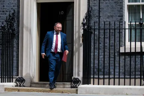 Getty Images MP Ian Murray leaves 10 Downing Street wearing a blue suit, white shirt and red tie