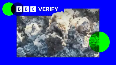 BBC A screengrab from a video showing the demolition of a building in Gaza City. Smoke is seen erupting from several buildings as explosives are detonated. The image is imposed over the BBC Verify colours and branding. 