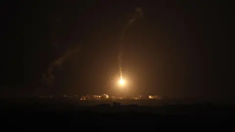 EPA A flare fired by the Israeli army lights up the sky above the outskirts of Gaza City