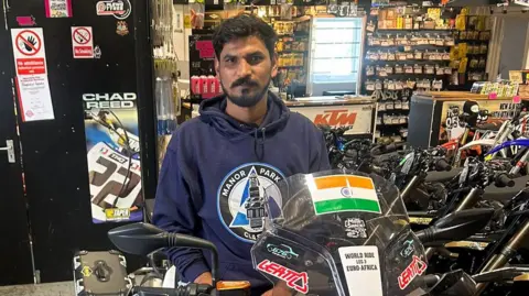 BBC Yogesh Alekari on a new bike in a motorcycle showroom
