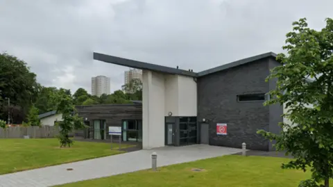 Google A grey and white hospital building on an overcast grey day