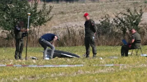 EPA/Shutterstock Polish military and drone experts inspect the crash site of a Russian drone in the village of Wohyń, eastern Poland. Photo: 10 September 2025