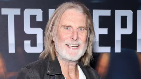 Getty Images David Threlfall smiling with shoulder-length hair and grey beard